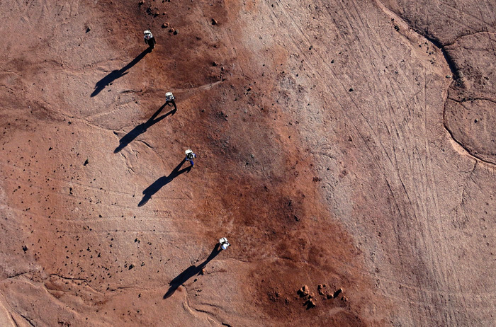 Members of Crew 138 walk across the desert in their simulated space suits at the Mars Desert Research Station in southern Utah. Photo by Jim Urquhart for National Geographic 3/18/2014